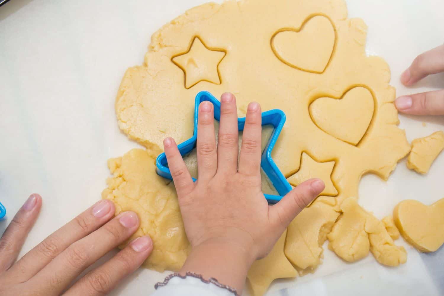 child cooking/ cutting out biscuits. Star shaped and love heart shaped playdough