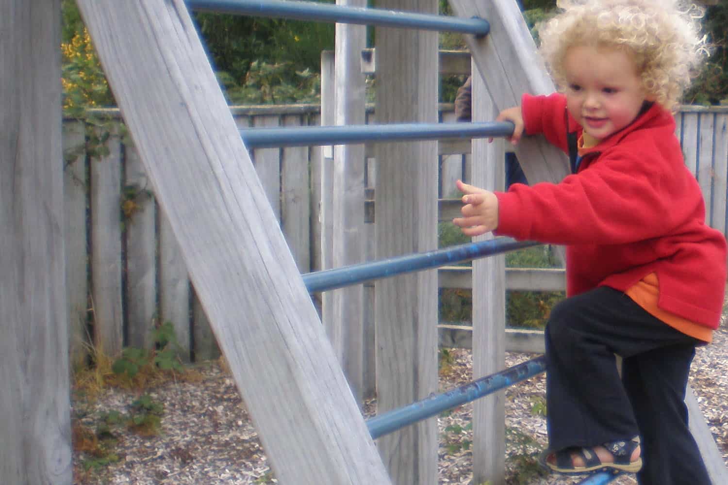 child climbing ladder of fort in ECE playground