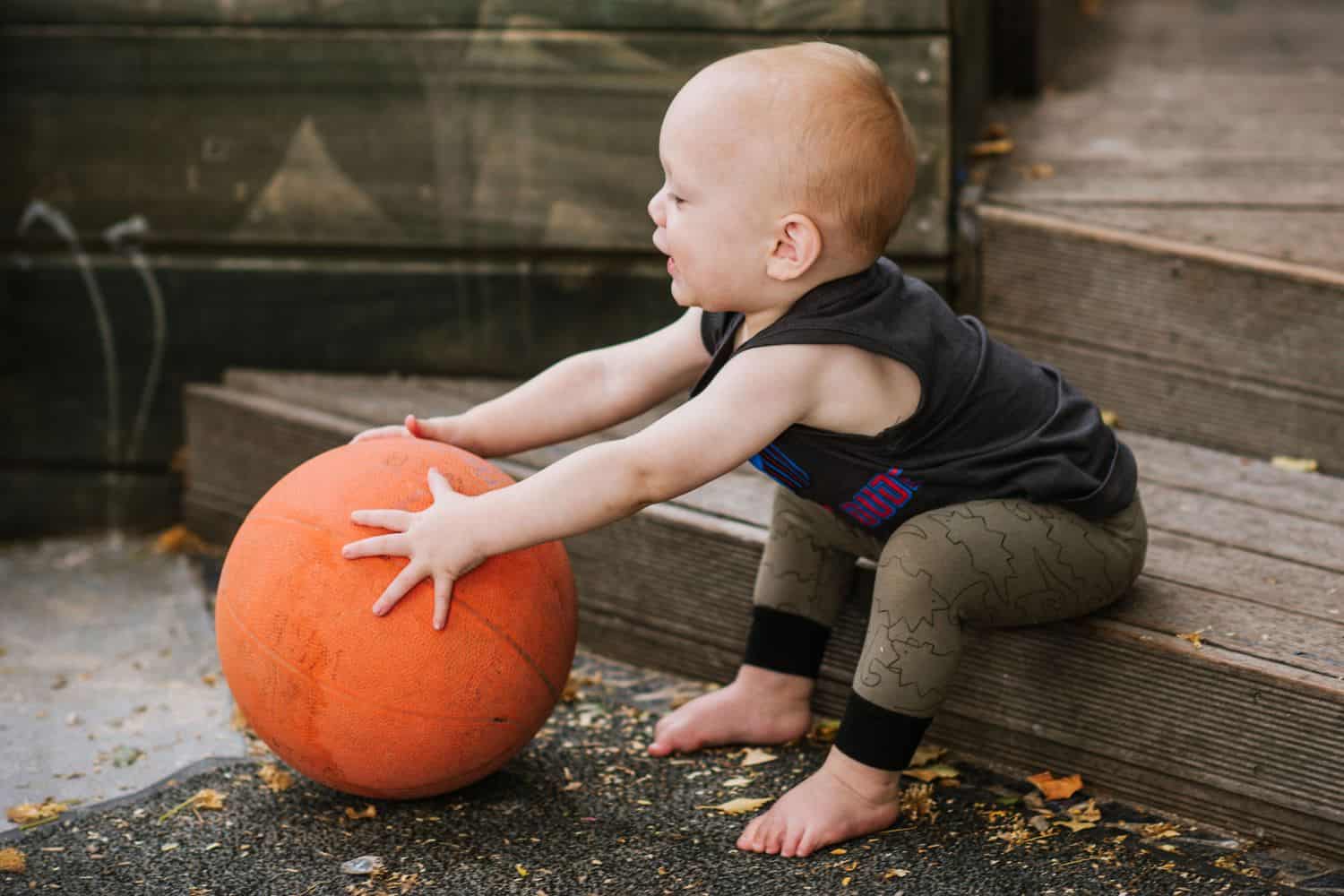 Infant holds large ball at early childhood centre
