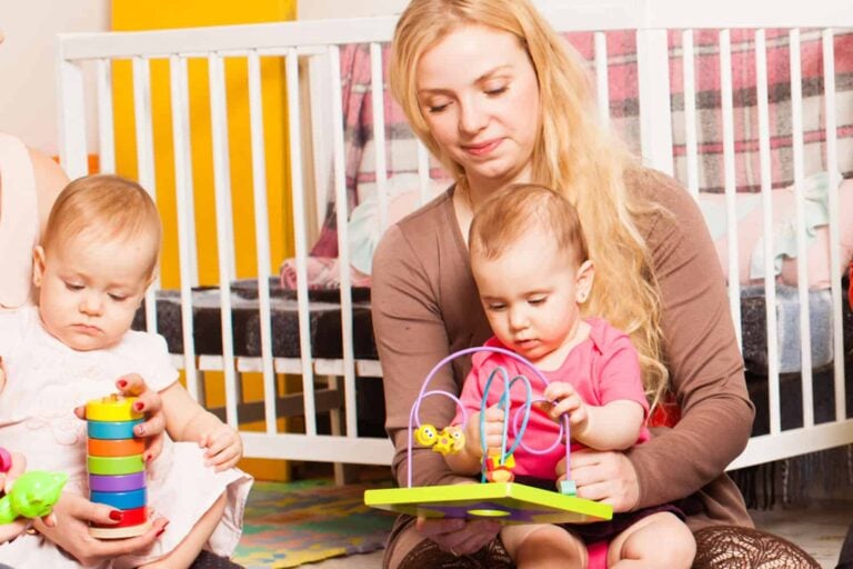 parents toddlers with toys cots in background