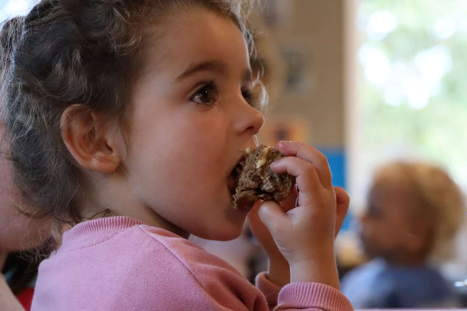 child eating a muffin at an early childhood centre