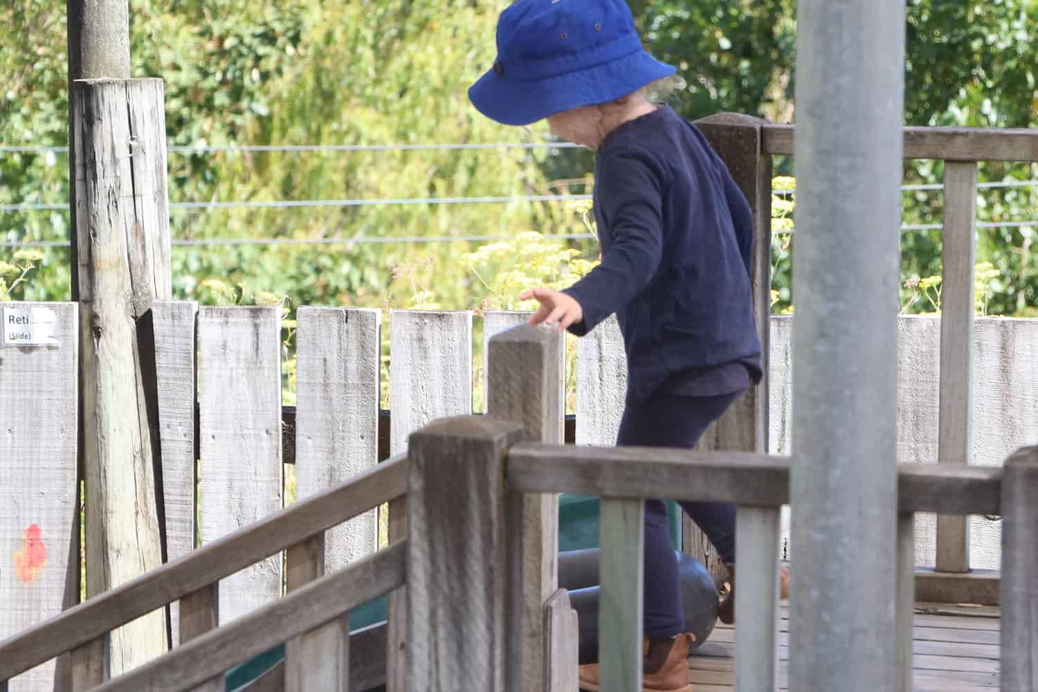 child up high on wooden fort at early childhood centre