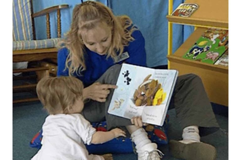 teacher on floor reading to toddler