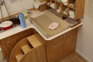 Men changing nappies. Nappy change table for infants at early childhood centre